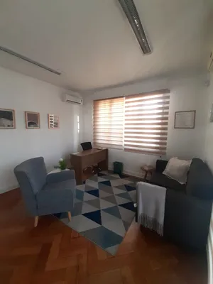 El mismo box de atención visto desde la puerta, con los sillones frente al escritorio.